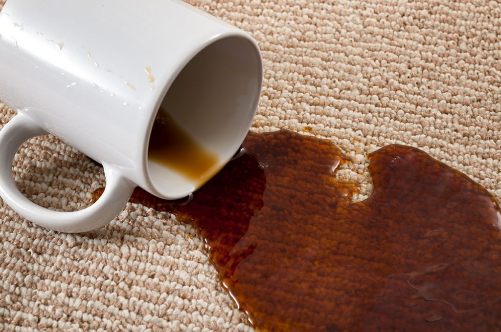 Tasse de café renversée sur un tapis avec une grosse tache de café