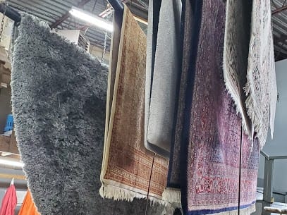 Area rugs hanging after cleaning at the PRO-SEC workshop