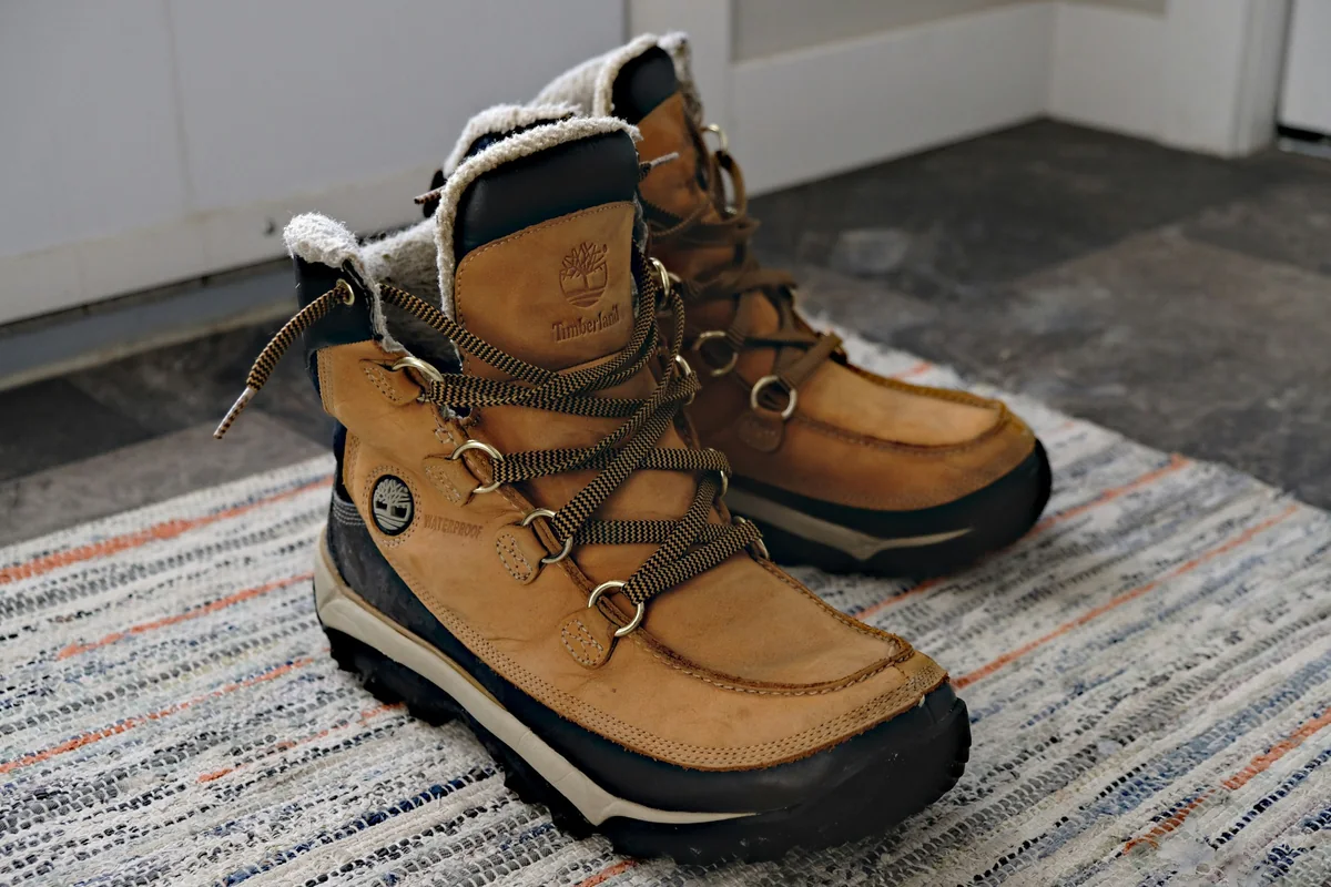 Bottes d’hiver sur un tapis d’entrée – nettoyage de tapis en automne
